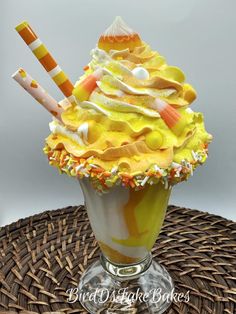 an ice cream sundae with candy and candies in it on a wicker table