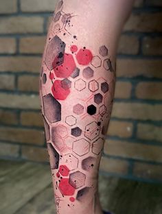 a man's leg with red and black ink on it, showing hexagonals