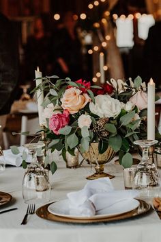 the table is set with flowers and candles