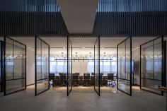 an empty conference room with glass walls and chairs