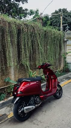 a red scooter is parked on the side of the road