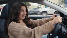 a woman sitting in the driver's seat of a car