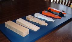 four pieces of wood sitting on top of a blue mat next to a toy car