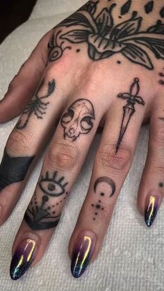 a woman's hand with tattoos on it and an eye, cross, skull and dagger