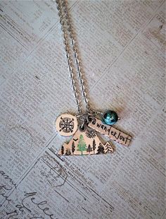 For Mountain Lovers!This necklace is a hand stamped mountain charm with various trees and a sunburst. The mountain measures 1.5x.5 inches. It also includes a hand stamped rectangle charm with "Wanderlust" and a matching gemstone bead. Add an Initial Charm for only $3. Charm is aluminum oval that measures .38x.25 inches.If you would like a different word or a gemstone, please specify in the Personalization box.Chain is Stainless Steel. Choose your chain length. Wanderlust Necklace, Baseball Earrings, Stamped Necklaces, Mountain Necklace, Mountain Lover, Hand Stamped Necklace, Different Words, Crystal Stars, Initial Charm