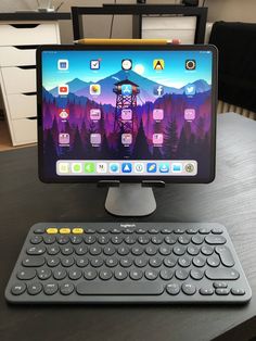 a computer keyboard sitting on top of a wooden table next to a monitor and mouse