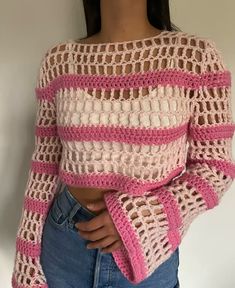 a woman wearing a pink and white crochet sweater