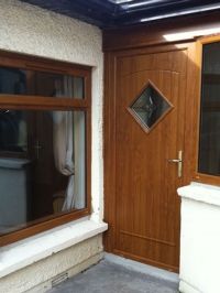 a wooden door and window in front of a house