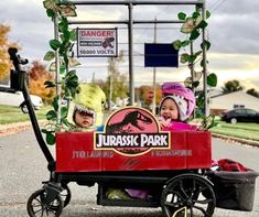 two children are riding in a toy cart