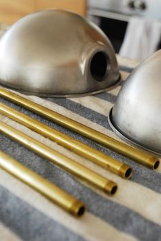 brass and silver objects are sitting on a striped tablecloth