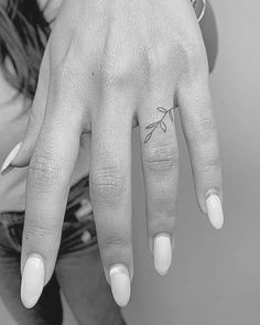 a woman's hand with a small tattoo on it