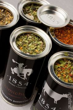 six tins filled with different types of herbs