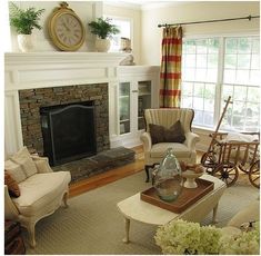 a living room filled with furniture and a fire place in front of a clock on the wall