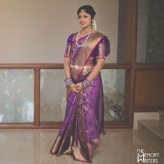 a woman in a purple and gold sari