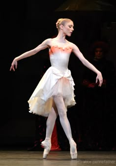 a ballerina in white is performing on stage