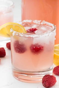 raspberry lemonade cocktail in a glass with ice and garnishes