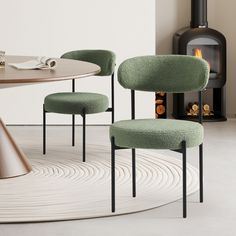 two green chairs sitting in front of a fire place next to a round wooden table