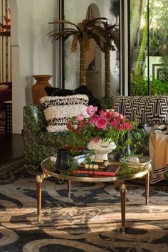 a living room filled with lots of furniture and flowers on top of a coffee table