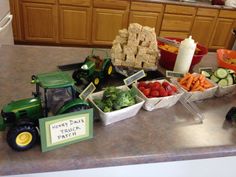 a table filled with farm fresh food and vegetables, including carrots, lettuce, cucumbers, celery, bread cubes, and crackers