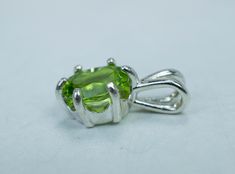 This is a beautiful and natural Peridot from Pakistan set in Sterling Silver. This amazing stone has the perfect deep lime green color that many want to see in Peridot and is one of those underrated stones that has a quite remarkable history. This Peridot has a great luster, and clarity as well. Peridot is August's Birthstone. This nicely sized 9mm x 7mm Cushion Peridot weighs 2.050cts and is beautifully accented by a 6 prong setting and will go great with most styles or occasions. They will eve Peridot Gemstones Gift, Green Peridot Birthstone Gemstones, Green Peridot Gemstones As Birthstones, Green Peridot Jewelry With Prong Setting, Green Peridot Gemstones For Gifts, Hallmarked Green Pendant Gemstones, Round Green Peridot Gemstones, Green Round Gemstones In Prong Setting, Peridot Pendant