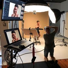 two men in front of a laptop on a camera set up for a photo shoot