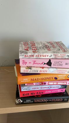 a stack of books sitting on top of a wooden table