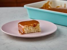 a piece of cake on a pink plate with caramel icing in the background