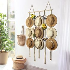 a wall mounted hat rack with hats hanging from it's sides and flowers in the middle