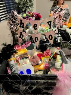 a basket filled with lots of stuff on top of a table next to a woman