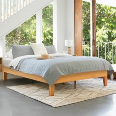 a bed sitting in the middle of a bedroom under a stair case next to a window