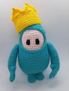 a crocheted blue stuffed animal with a yellow crown on it's head