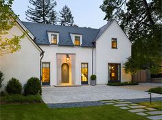 a large white house with two windows and a door in the front yard at night