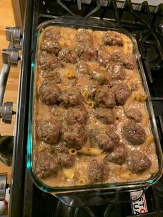 a casserole dish with meatballs and noodles in it sitting on the stove