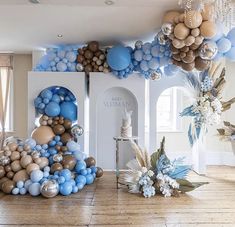 a room with balloons and decorations on the floor, including blue and gold balls hanging from the ceiling