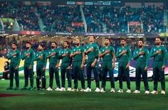 a group of men standing on top of a field next to each other in front of a crowd