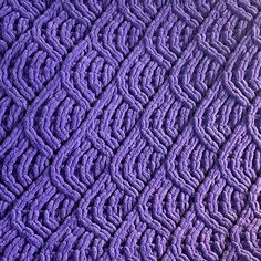 a close up view of the texture of a knitted blanket in purple and black