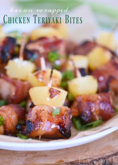 chicken teriyaki bites with pineapples and green onions on a white plate