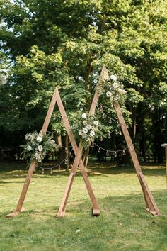 an outdoor ceremony setup with flowers and greenery in the shape of three triangulars