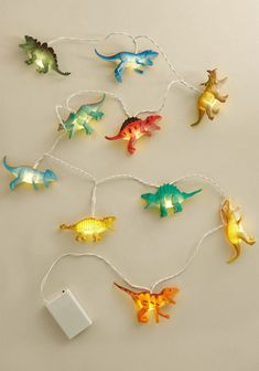 the string lights are shaped like dinosaurs and have different colored heads on each one side