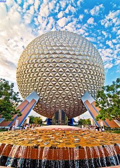 the spaceship ball at disney world is surrounded by water and trees in front of it