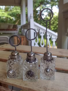 three salt and pepper shakers sitting on top of a wooden table