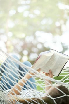 a person laying in a hammock reading a book with the words books our daughters read and why they matter