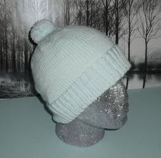 a white knitted hat sitting on top of a mannequin head