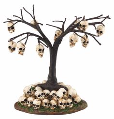 a group of skulls sitting on top of a base under a tree with no leaves