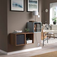 a living room filled with furniture next to a wall mounted lamp and pictures on the wall