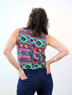 "This is a cheerful 90s vintage buttery soft rayon vest in bright, almost neon, lime green, purple, pink, blue and yellow! The print combines stylized flowers with zig zag stripes and geometric shapes. It has ties at the back to adjust the waist and it's fully lined with black satin inside. It closes with three large clear and black striped plastic novelty buttons. The vest is in very good clean vintage condition, no flaws noted. The label says \"Accordeon, Body 100% Rayon, Lining 100% Acetate, Vibrant Green Cotton Tops, Vibrant Green Cotton Top, Multicolor Retro Summer Vest, Retro Multicolor Summer Vest, Colorful Vibrant Print Fitted Tops, Colorful Fitted Tops With Vibrant Print, Colorful Fitted Top With Vibrant Print, Retro Green Sleeveless Top, Fitted Colorful Vibrant Print Tops