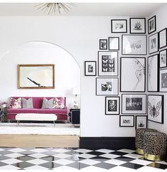 a living room with black and white checkered flooring, framed pictures on the wall