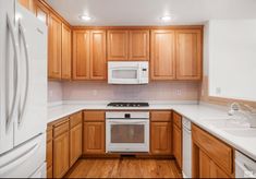 a kitchen with wooden cabinets and white appliances