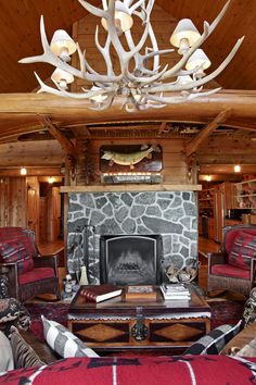 a living room filled with lots of furniture and a fire place under a chandelier