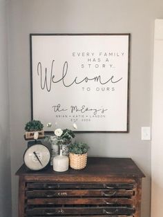 a wooden dresser sitting next to a wall with a sign above it that says, every family has a story welcome to ourss